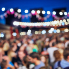 large group of people outside blurred with hanging lights