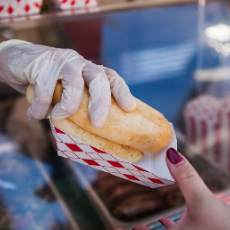 photo of a person with a glove handing food to a person