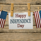 Clothesline with American Flags and Happy Independence Day tag clipped on the line